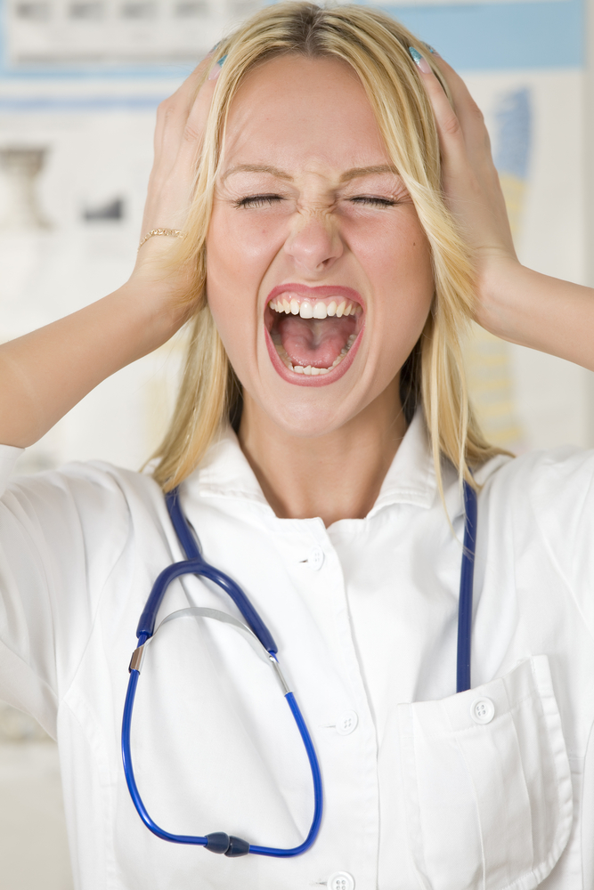Woman holding her head with a stethoscope around her neck