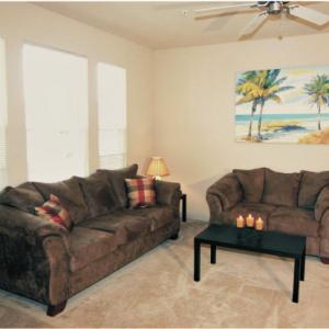 Interior image of a living room with two brown couches and a black coffee table