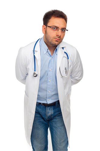A male doctor in a white coat with jeans on and a stethoscope around his neck