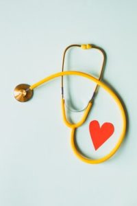 A yellow stethoscope with a red heart